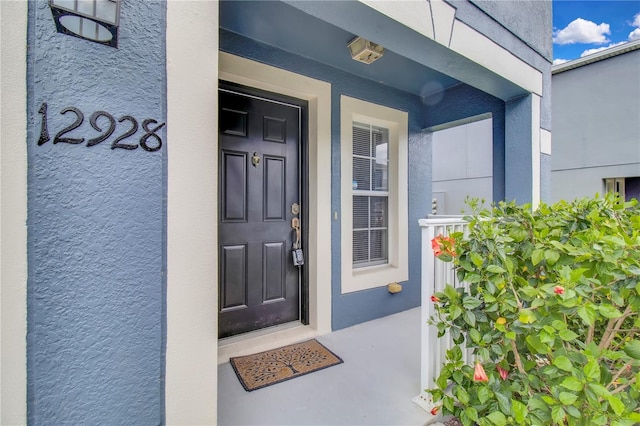 view of exterior entry featuring stucco siding