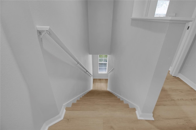 stairway with baseboards and wood finished floors