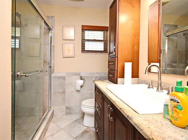 2900 Cullen Lake Shore Dr, Belle Isle, FL 32812 - bathroom featuring a stall shower, vanity, toilet, tile patterned flooring, and tile walls