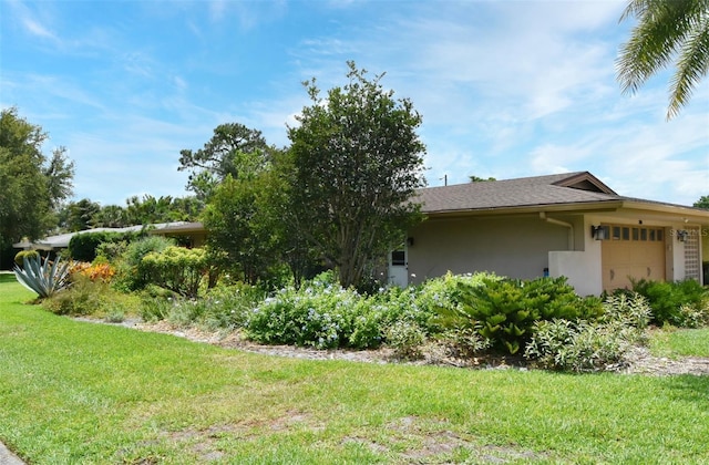 2900 Cullen Lake Shore Dr, Belle Isle, FL 32812 - view of home's exterior with stucco siding, an attached garage, and a lawn