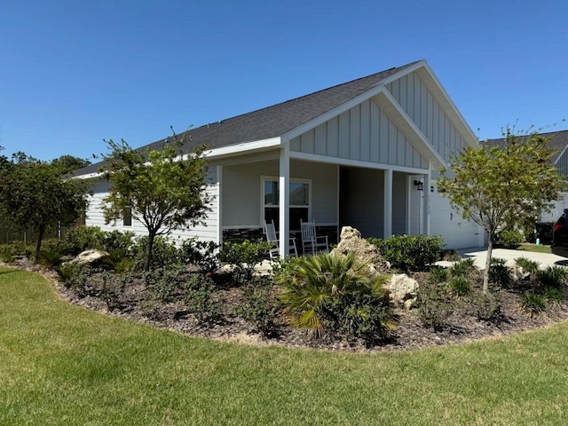 6709 SW 15th Pl, Gainesville, FL 32607 - view of property exterior with board and batten siding, an attached garage, covered porch, a lawn, and a shingled roof