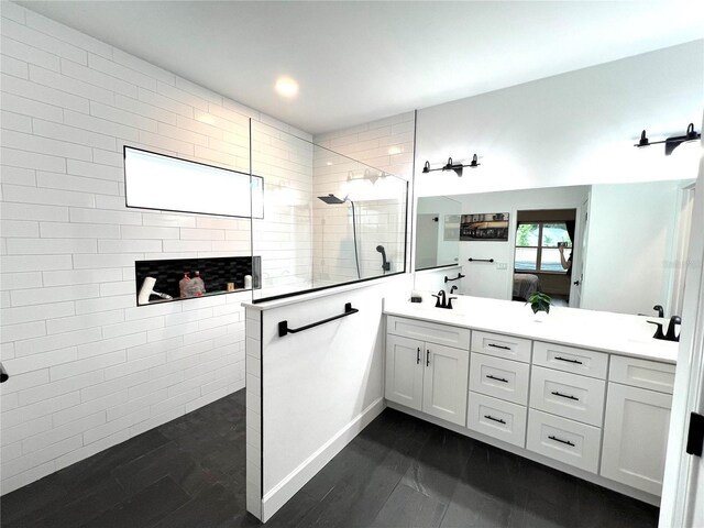 6709 SW 15th Pl, Gainesville, FL 32607 - bathroom featuring double vanity, wood finished floors, a sink, a walk in shower, and ensuite bathroom