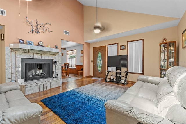 living room featuring visible vents, wood finished floors, and high vaulted ceiling