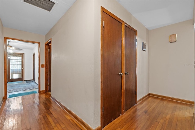 corridor featuring light wood-type flooring, baseboards, and visible vents