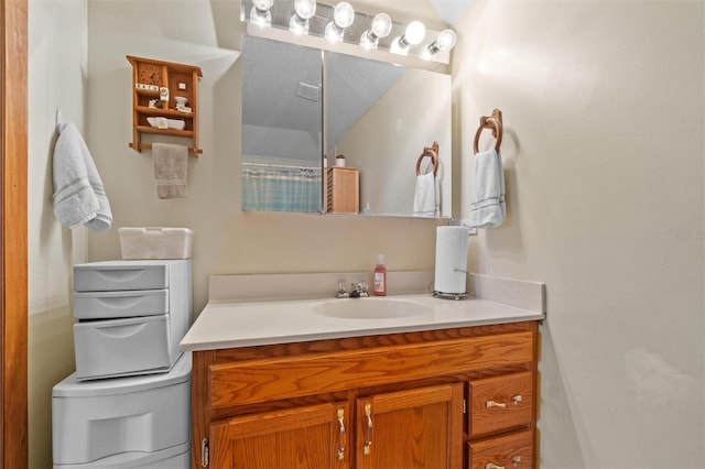 bathroom with toilet, vaulted ceiling, and vanity