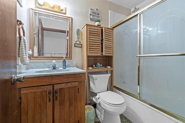bathroom with vanity, shower / bath combination with glass door, and toilet