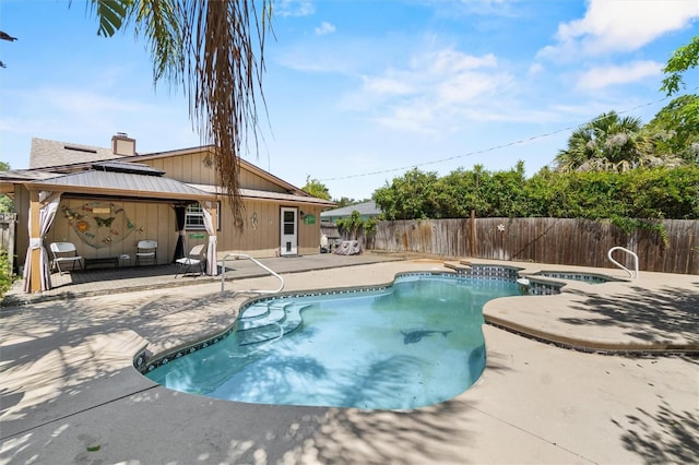 view of swimming pool with a gazebo, a pool with connected hot tub, a fenced backyard, and a patio area