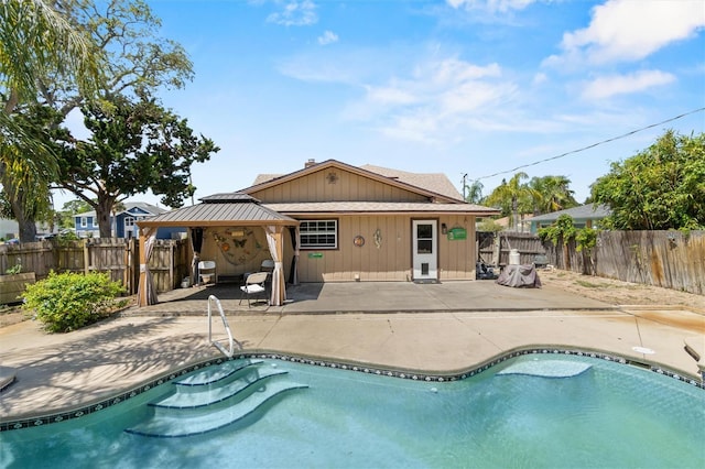 back of property with a gazebo, a fenced backyard, a fenced in pool, and a patio