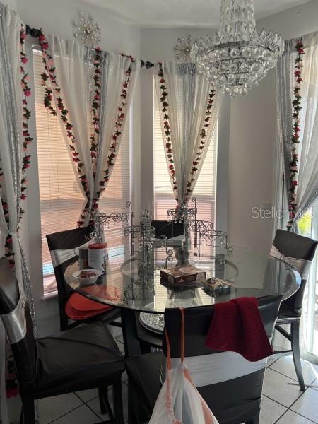 dining space with a chandelier and light tile patterned floors