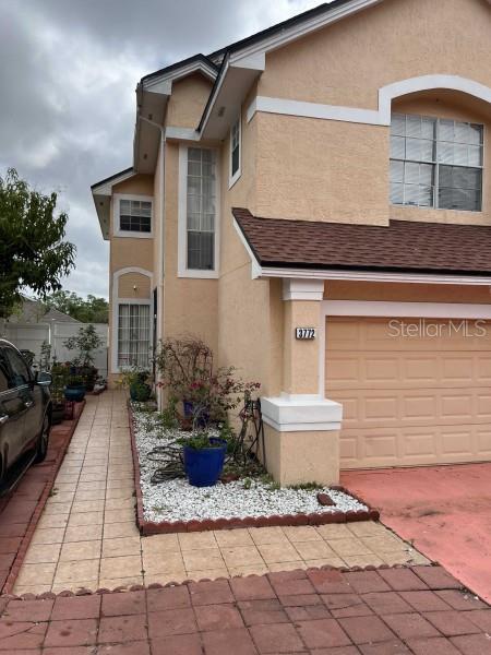 traditional home with an attached garage and stucco siding