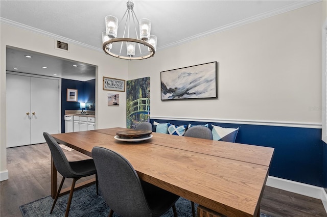 111 Crown Oaks Way Unit 101, Longwood, FL 32779 - dining room featuring a chandelier, wood finished floors, and crown molding