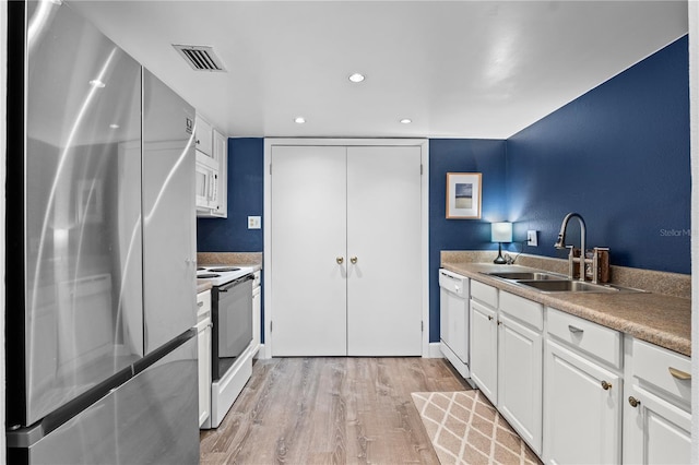 111 Crown Oaks Way Unit 101, Longwood, FL 32779 - kitchen featuring white appliances, a sink, light wood-type flooring, white cabinetry, and recessed lighting