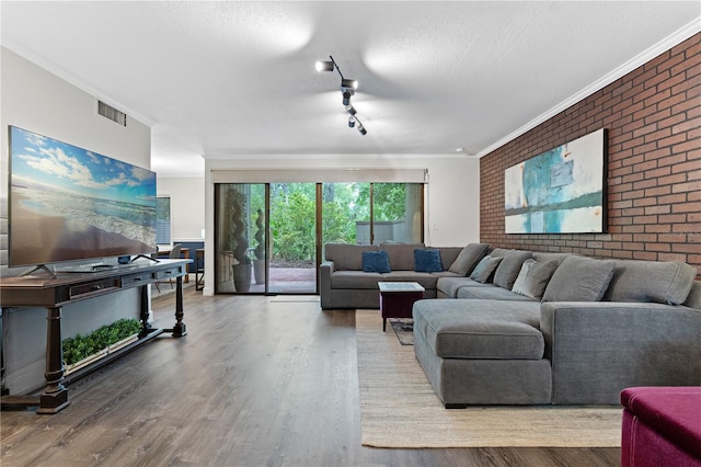 111 Crown Oaks Way Unit 101, Longwood, FL 32779 - living area with wood finished floors, ornamental molding, rail lighting, brick wall, and a textured ceiling