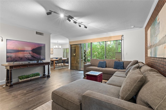 111 Crown Oaks Way Unit 101, Longwood, FL 32779 - living area featuring a chandelier, wood finished floors, track lighting, and a textured ceiling