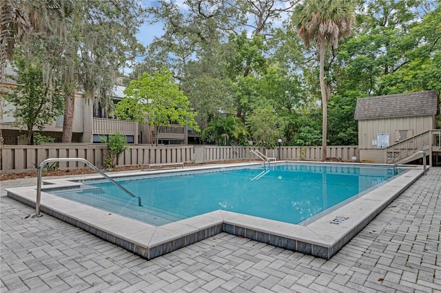 111 Crown Oaks Way Unit 101, Longwood, FL 32779 - community pool featuring a patio area, an outdoor structure, and view of wooded area