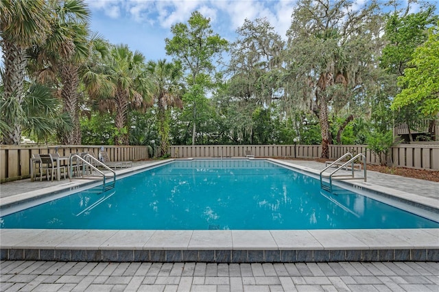 111 Crown Oaks Way Unit 101, Longwood, FL 32779 - community pool featuring view of wooded area, a fenced backyard, and a patio area