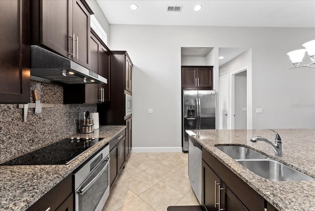13865 Granger Ave, Orlando, FL 32827 - kitchen featuring dark brown cabinetry, appliances with stainless steel finishes, tasteful backsplash, a sink, and under cabinet range hood