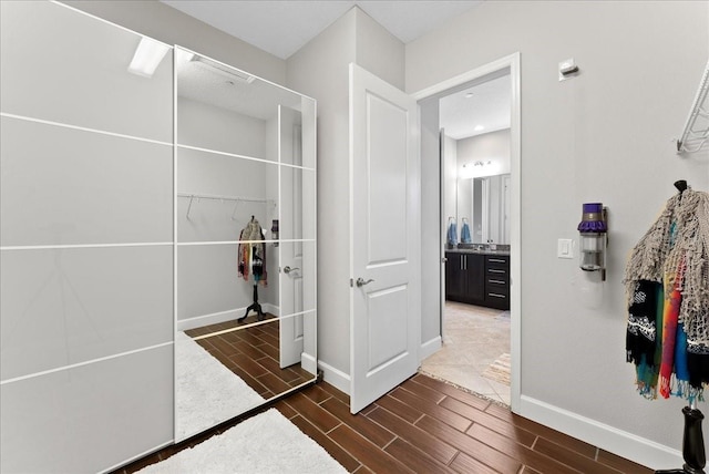 13865 Granger Ave, Orlando, FL 32827 - bathroom featuring baseboards, wood finish floors, a walk in closet, and vanity