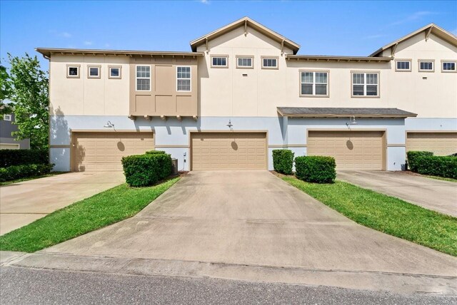 13865 Granger Ave, Orlando, FL 32827 - townhome / multi-family property with a garage, stucco siding, and concrete driveway