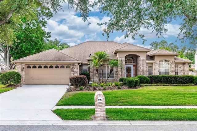 603 Yorkshire Dr, Oviedo, FL 32765 - view of front of house with a garage, brick siding, a front yard, and driveway