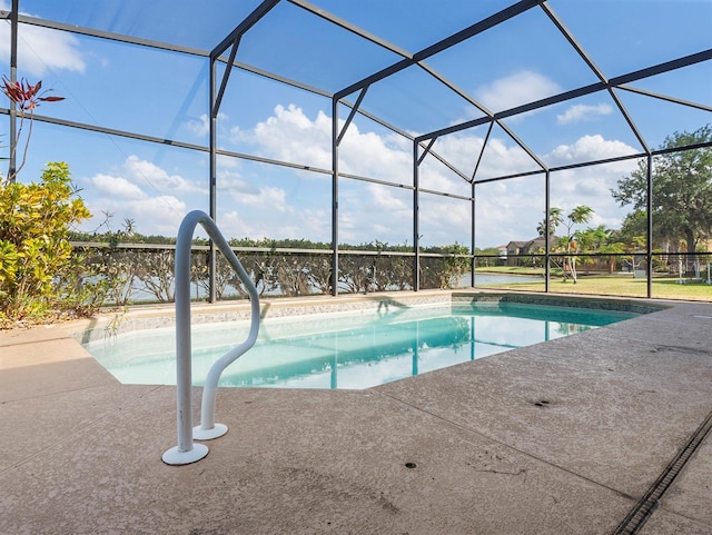 outdoor pool with a patio and glass enclosure