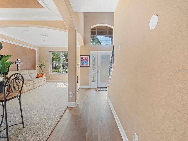 entryway featuring crown molding, baseboards, and wood finished floors