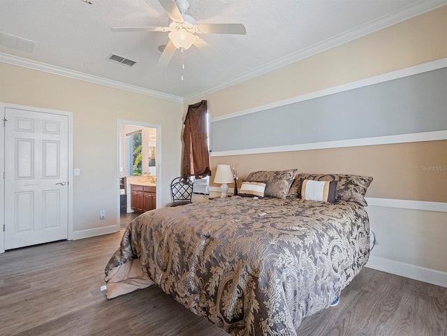 bedroom featuring baseboards, ornamental molding, visible vents, and wood finished floors