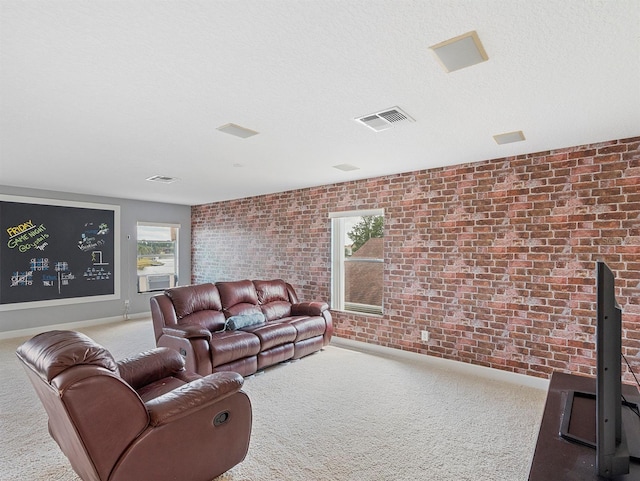 carpeted living area with visible vents, baseboards, and brick wall
