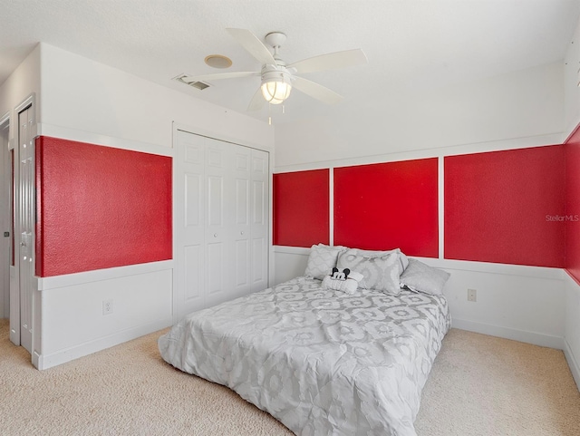 carpeted bedroom featuring a closet, visible vents, and a ceiling fan