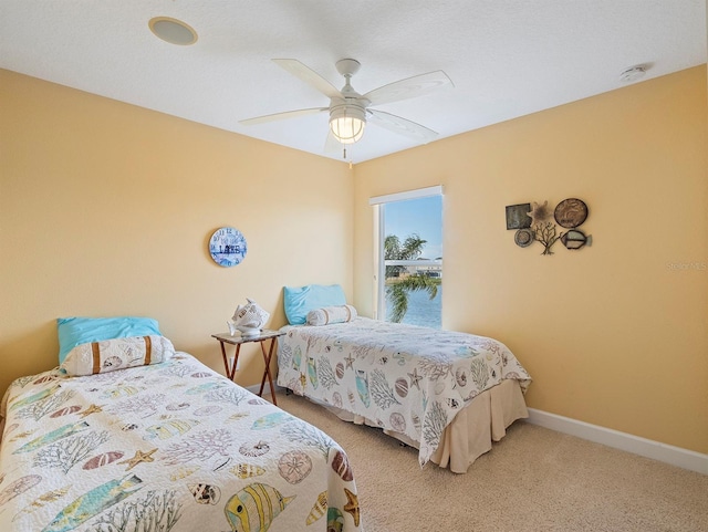 carpeted bedroom with baseboards and a ceiling fan