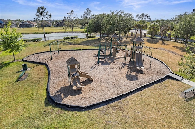 community jungle gym with a yard, fence, and a water view