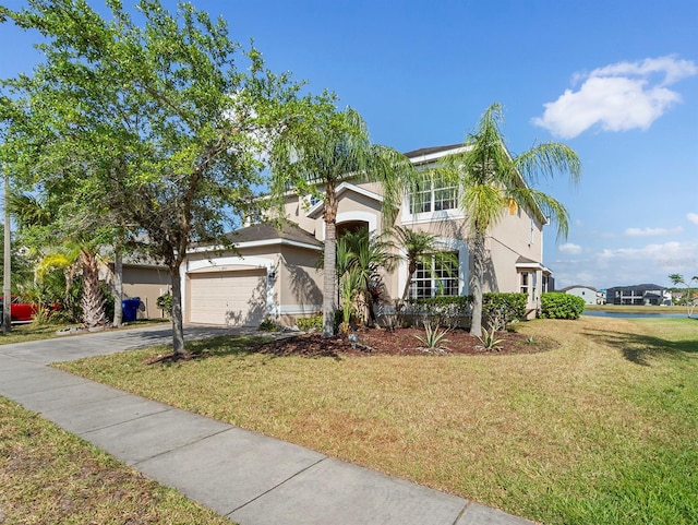 view of front of property with an attached garage, stucco siding, driveway, and a front yard