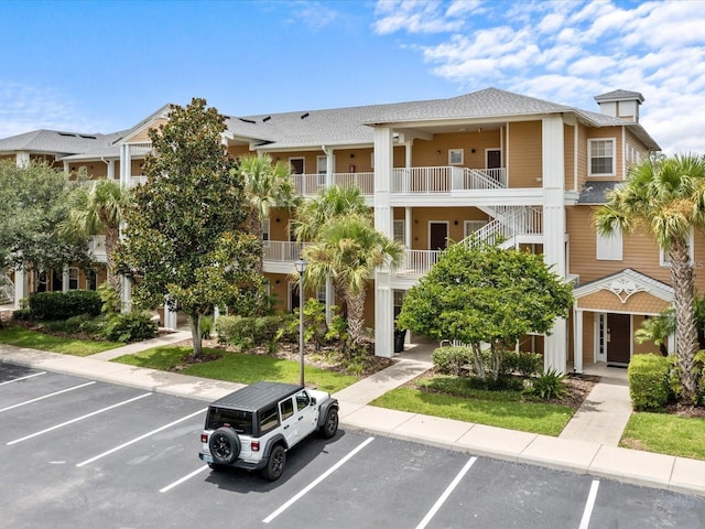 view of building exterior featuring uncovered parking and stairway