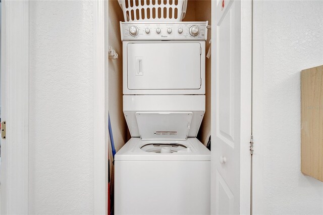 510 Rum Run Unit 33-510, Davenport, FL 33837 - washroom with stacked washing machine and dryer and a textured wall