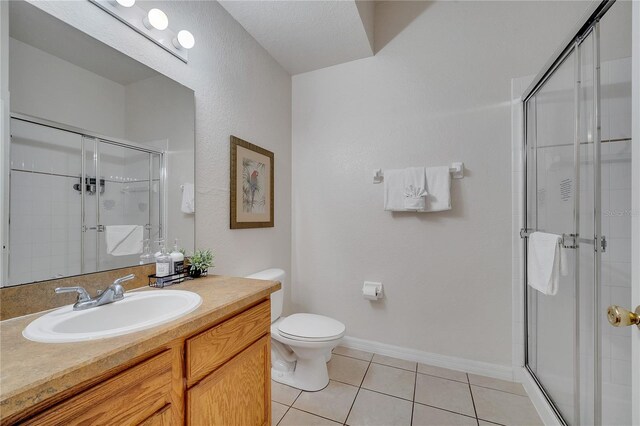 510 Rum Run Unit 33-510, Davenport, FL 33837 - bathroom with tile patterned floors, a stall shower, toilet, vanity, and baseboards