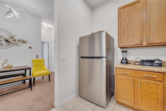 510 Rum Run Unit 33-510, Davenport, FL 33837 - kitchen featuring freestanding refrigerator, light countertops, light tile patterned flooring, baseboards, and light carpet