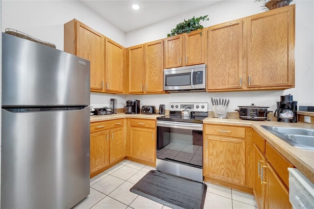 510 Rum Run Unit 33-510, Davenport, FL 33837 - kitchen featuring stainless steel appliances, light countertops, light tile patterned floors, a sink, and recessed lighting