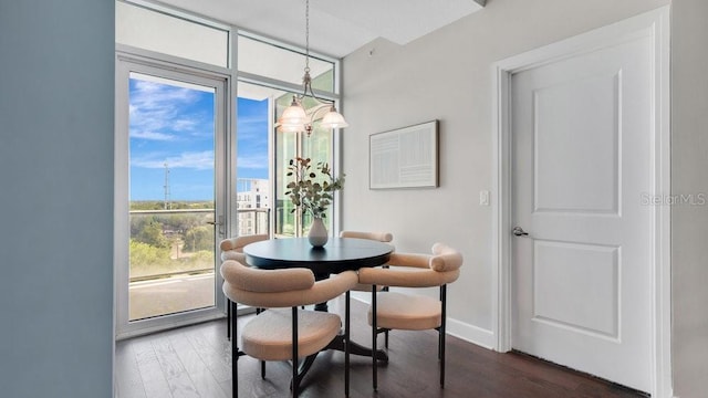 dining room with dark wood-style flooring, baseboards, a wall of windows, and an inviting chandelier
