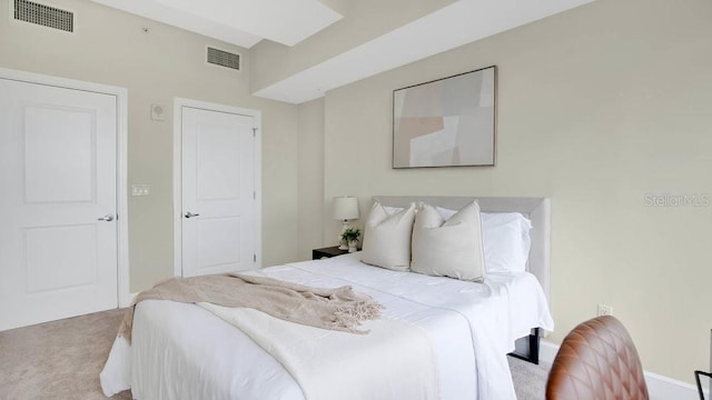 carpeted bedroom featuring visible vents