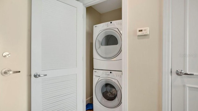 laundry area with stacked washer / drying machine and laundry area
