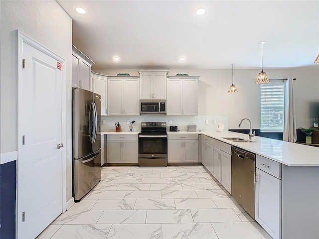 303 Ocean Course Ave, Davenport, FL 33896 - kitchen with marble finish floor, a peninsula, a sink, gray cabinetry, and stainless steel appliances