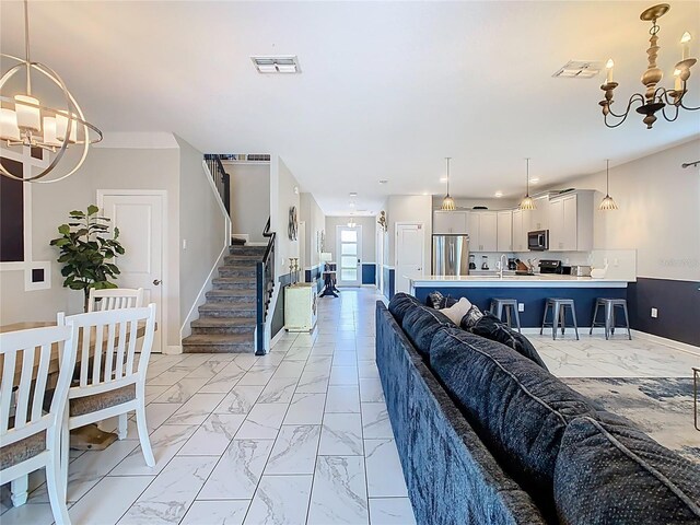 303 Ocean Course Ave, Davenport, FL 33896 - living room featuring baseboards, an inviting chandelier, and marble finish floor