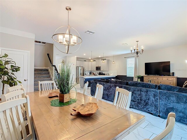 303 Ocean Course Ave, Davenport, FL 33896 - dining space featuring stairs, marble finish floor, an inviting chandelier, and visible vents