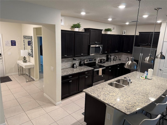197 Jetty Way, Davenport, FL 33897 - kitchen featuring stainless steel appliances, a sink, dark cabinets, a kitchen breakfast bar, and recessed lighting
