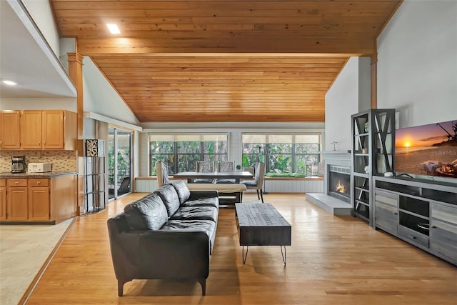 9503 Alice Ln, Riverview, FL 33578 - living room featuring wood ceiling, light wood finished floors, high vaulted ceiling, and a warm lit fireplace