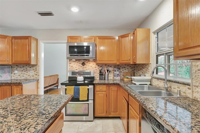 9503 Alice Ln, Riverview, FL 33578 - kitchen with stainless steel appliances, decorative backsplash, and dark stone countertops