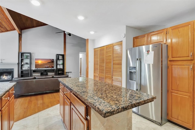 9503 Alice Ln, Riverview, FL 33578 - kitchen with stainless steel refrigerator with ice dispenser, dark stone counters, a kitchen island, open floor plan, and recessed lighting
