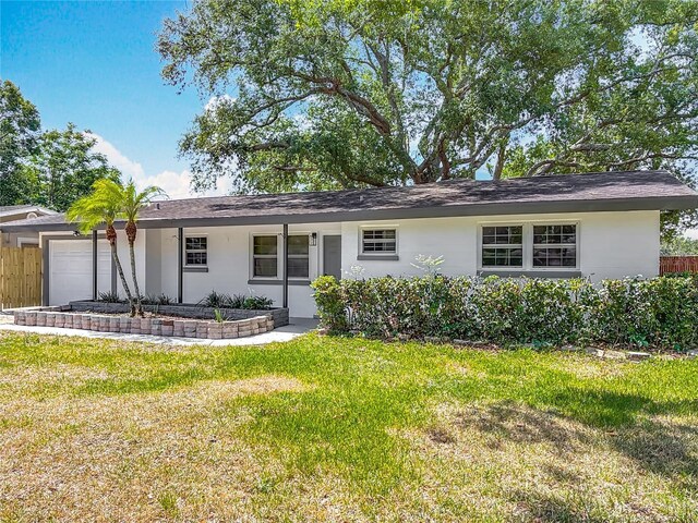 1298 Scottsdale Dr, Ormond Beach, FL 32174 - ranch-style home with a garage, a front lawn, roof with shingles, and stucco siding