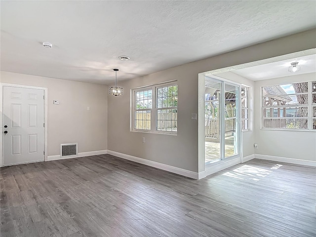 1298 Scottsdale Dr, Ormond Beach, FL 32174 - unfurnished dining area with baseboards, a notable chandelier, wood finished floors, and visible vents