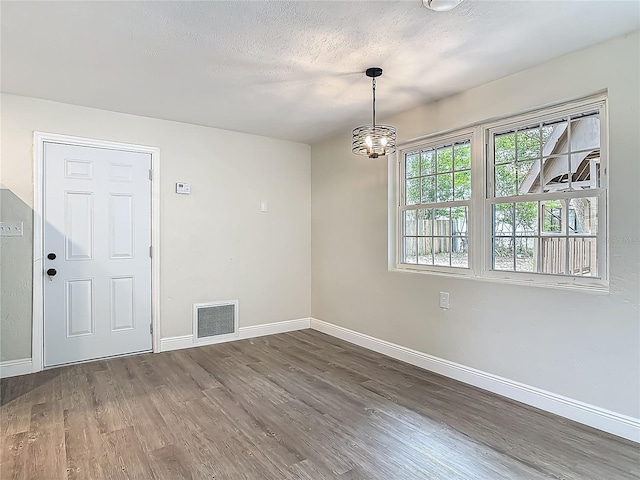 1298 Scottsdale Dr, Ormond Beach, FL 32174 - unfurnished room with visible vents, baseboards, wood finished floors, and an inviting chandelier